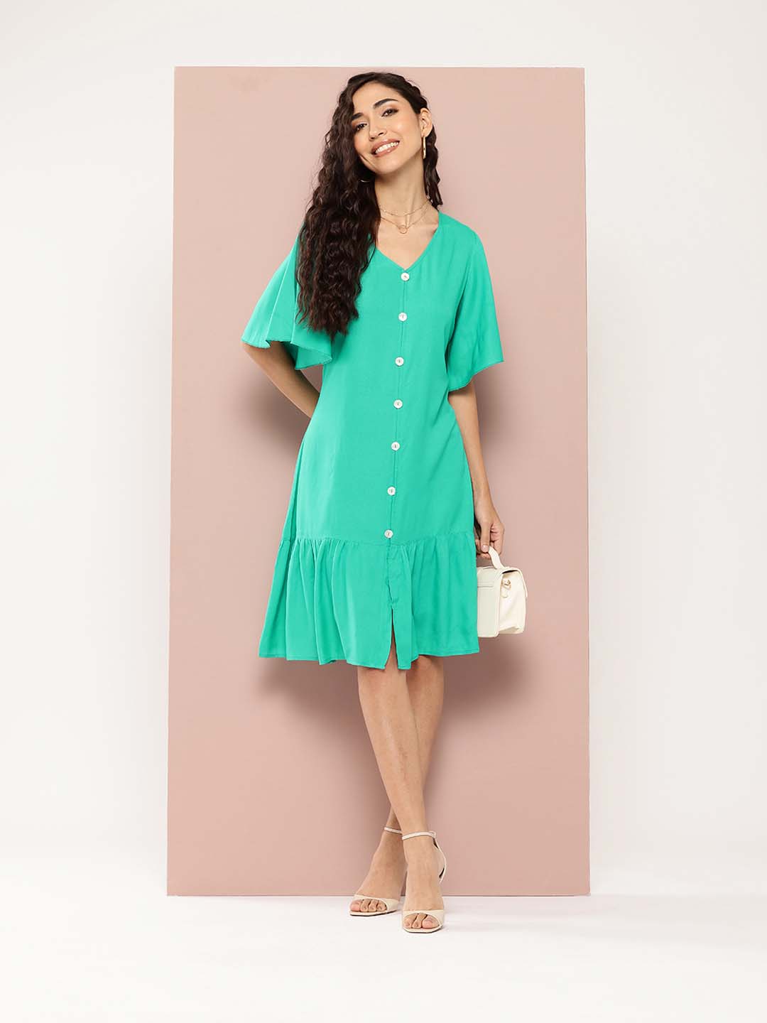 Solid rayon A-line style with a V-neckline and ruffle details. It features decorative show buttons